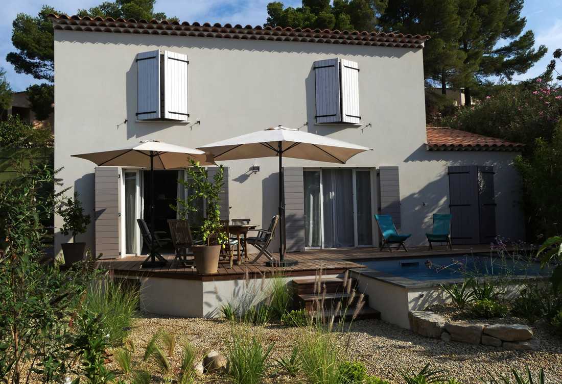 Piscine semi-enterrée avec terrasse bois et jardin écologique