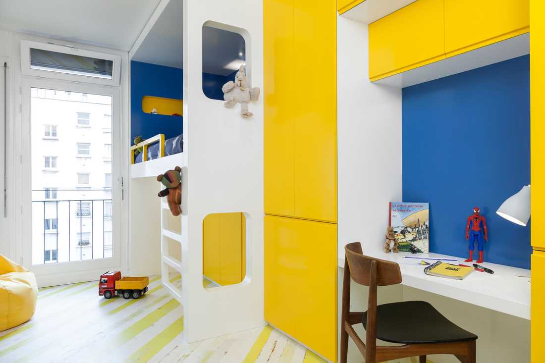 Aménagement d'une chambre d'enfant moderne avec un lit cabanne et des rangements de couleur jaunes 