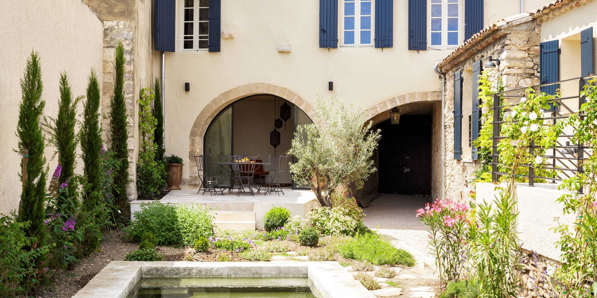 Terrasse d'une maison ancienne en pierre aménagée par un paysagiste de la région de Nîmes